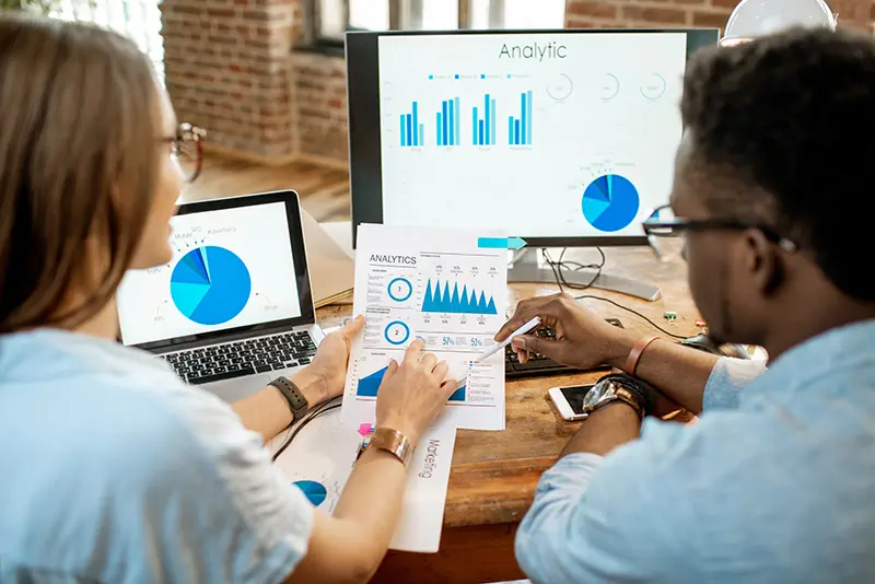Small business owner reviewing website analytics on a laptop to fix common website mistakes and improve customer engagement.